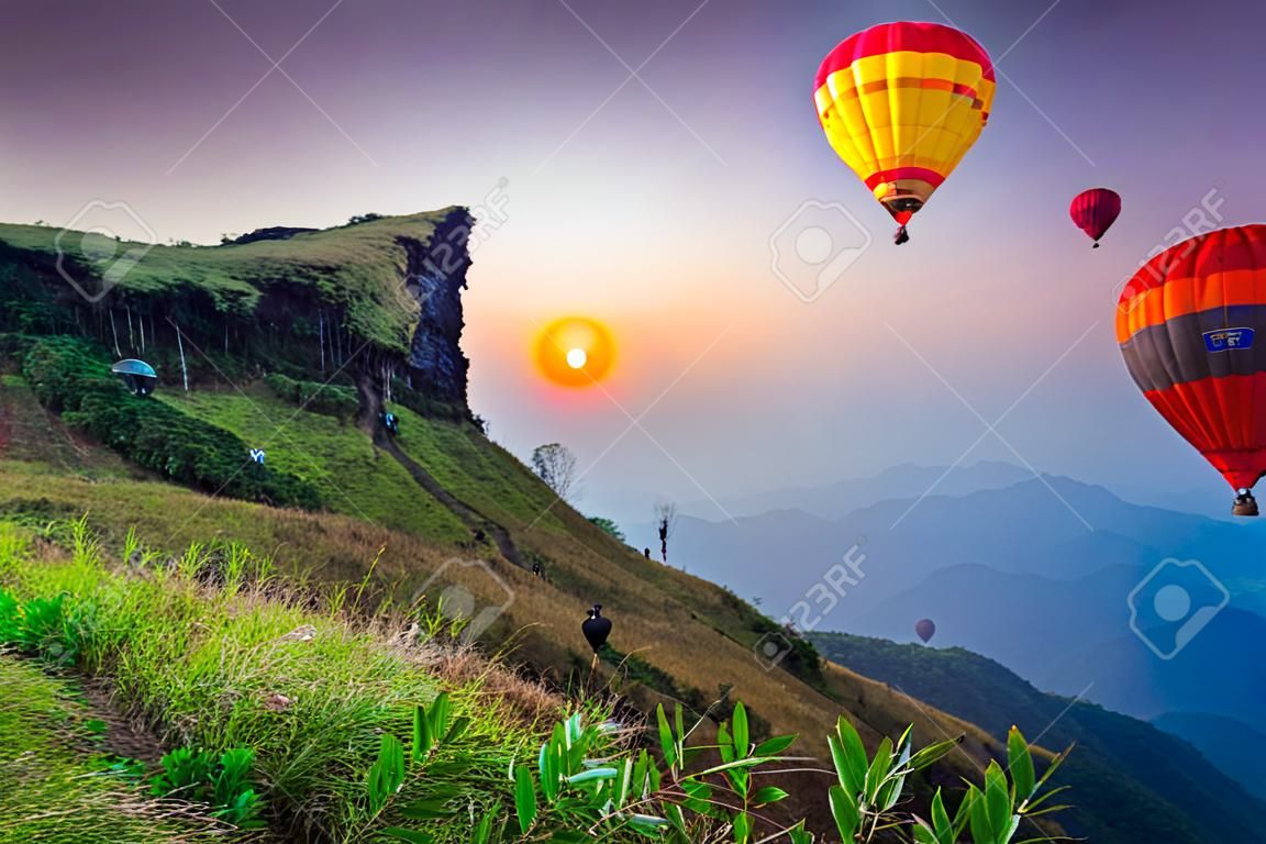 Colorful hot air balloons flying over mountain at Phu Chi fa National Park in the morning. Chiang Rai Province, Thailand
