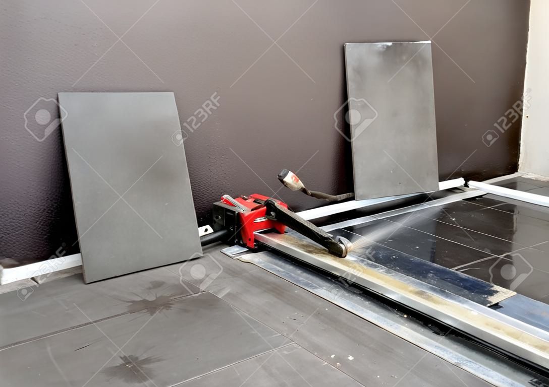 used tile cutter on newly installed porcellenato tiled floor