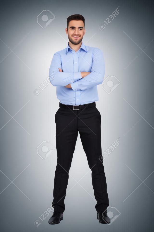 Young confident business man with crossed arms looking at camera. Full body length portrait isolated over white studio background.