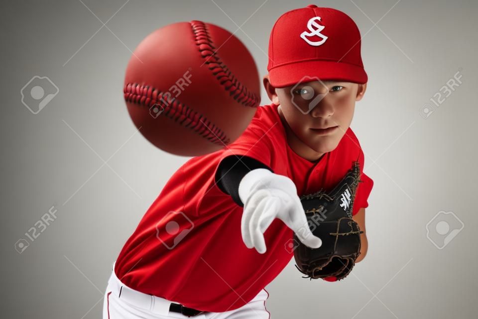 retrato de um jogador de beisebol adolescente bonito no uniforme vermelho e branco no fundo colorido