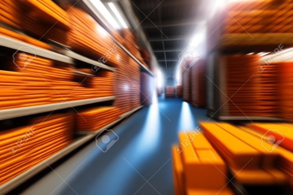 Warehouse industrial premises for storing materials and wood, there is a forklift for containers. Concept logistics, transport. Motion blur effect. Bright sunlight.