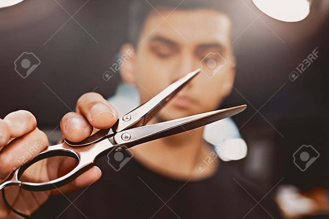Barber shop. Close-up of barber holds clip-on hair clipper barbershop