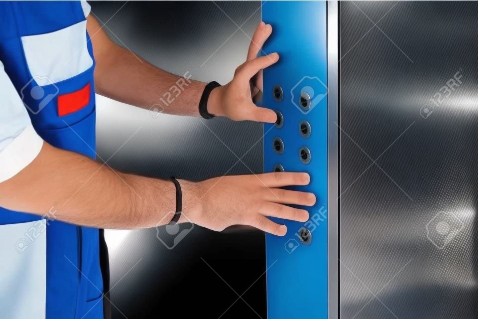 Levante o homem machinista consertando o mecanismo de fixação ou ajuste do elevador.