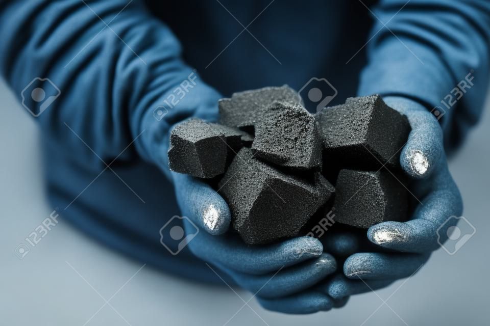 Mijnwerker houdt steenkoolpalm. Concept mijnbouw, Top view
