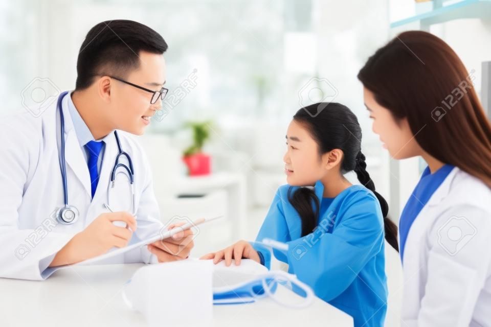Young asian girl with sore throat come to visit doctor with her mother at clinic