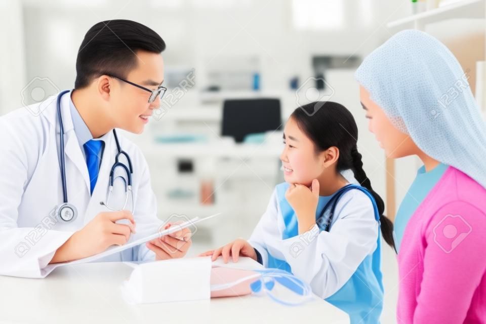 Une jeune fille asiatique souffrant de maux de gorge vient consulter un médecin avec sa mère à la clinique