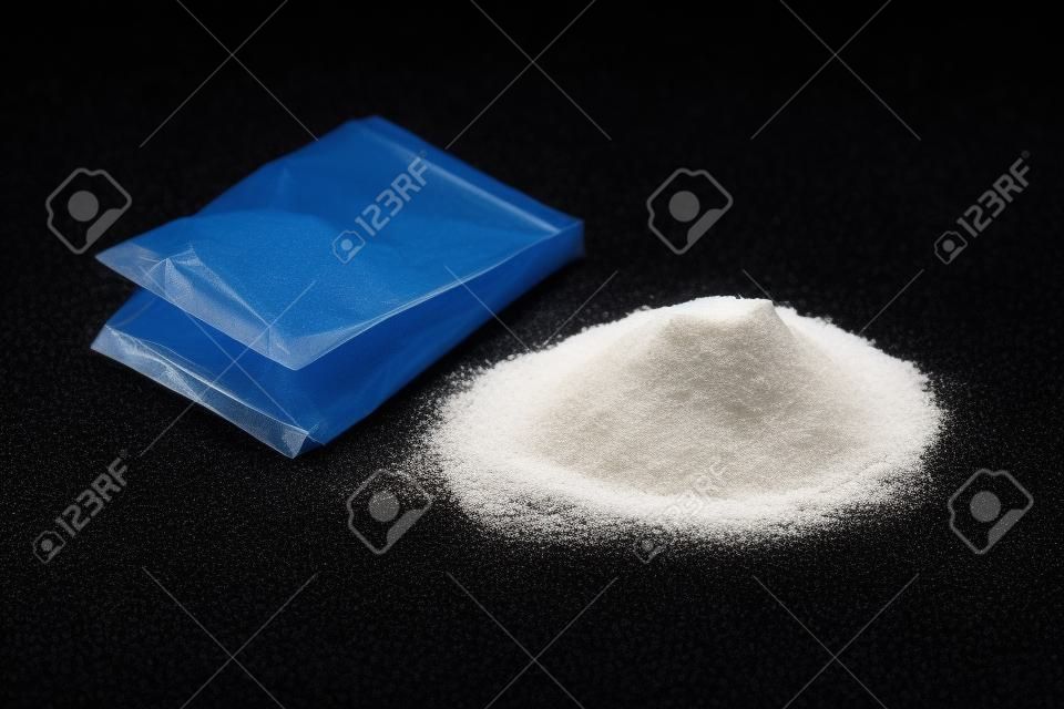 Cocaine in plastic packet on black background, closeup
