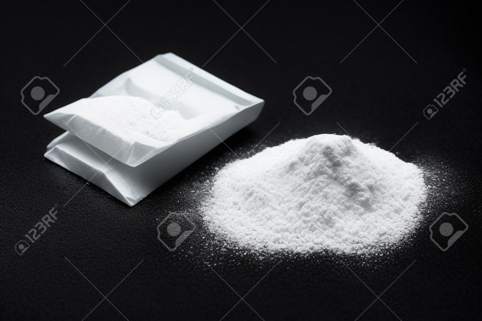Cocaina nel pacchetto di plastica su fondo nero, primo piano