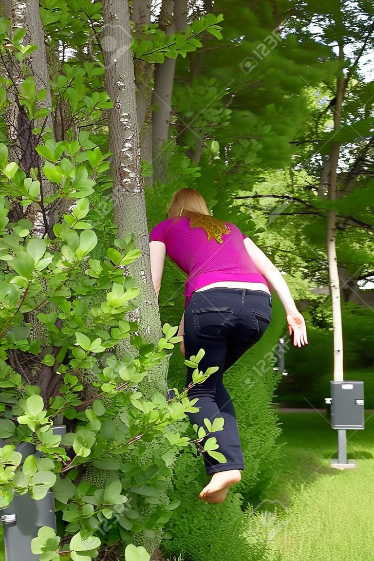 mujer está orinando al aire libre detrás de los arbustos