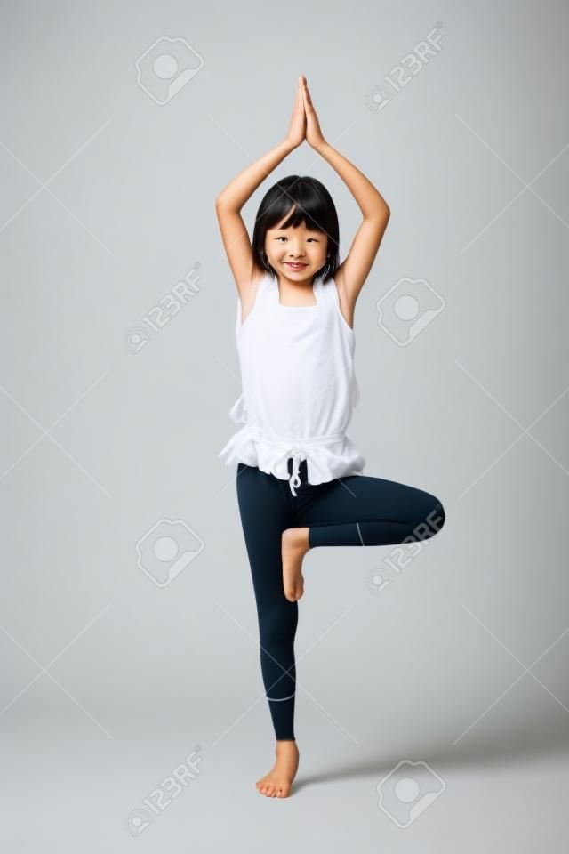 Petits asiatiques fille faisant des exercices de yoga isolé sur blanc