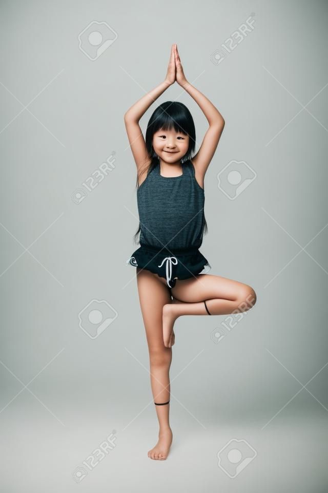 ヨガ体操分離された白で小さなアジアの女の子