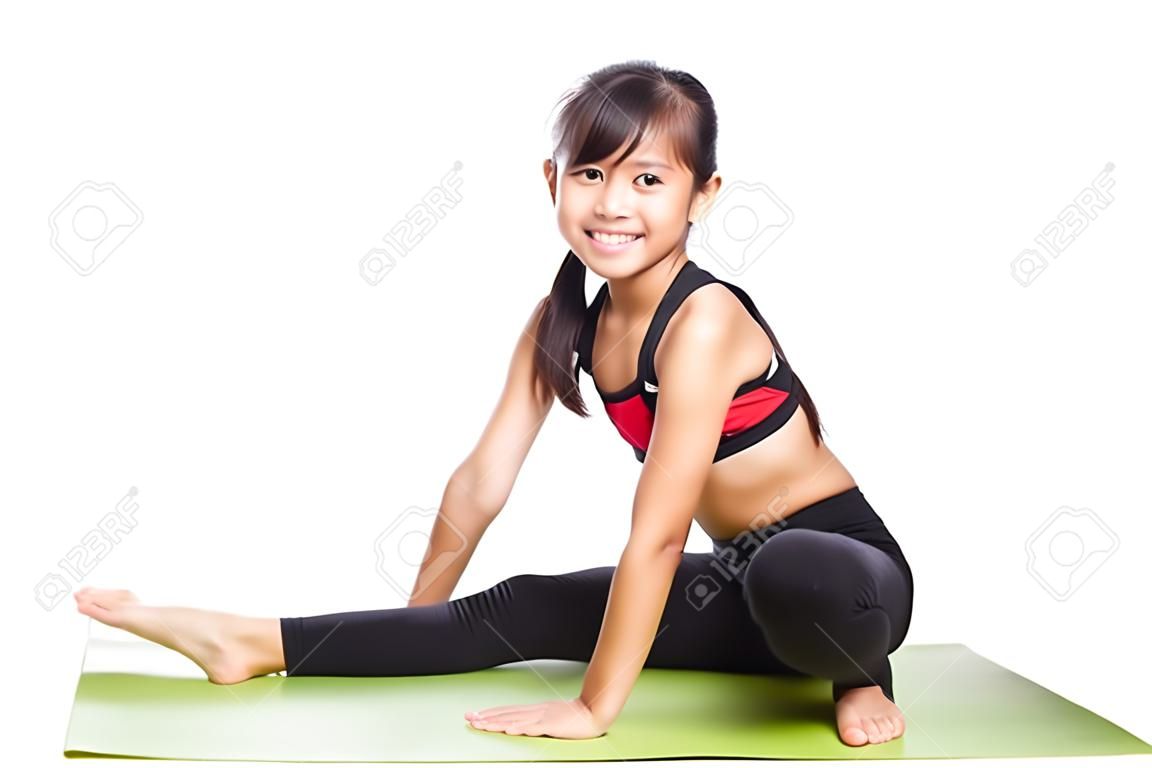 Piccola ragazza asiatica facendo esercizi di fitness, isolati su bianco