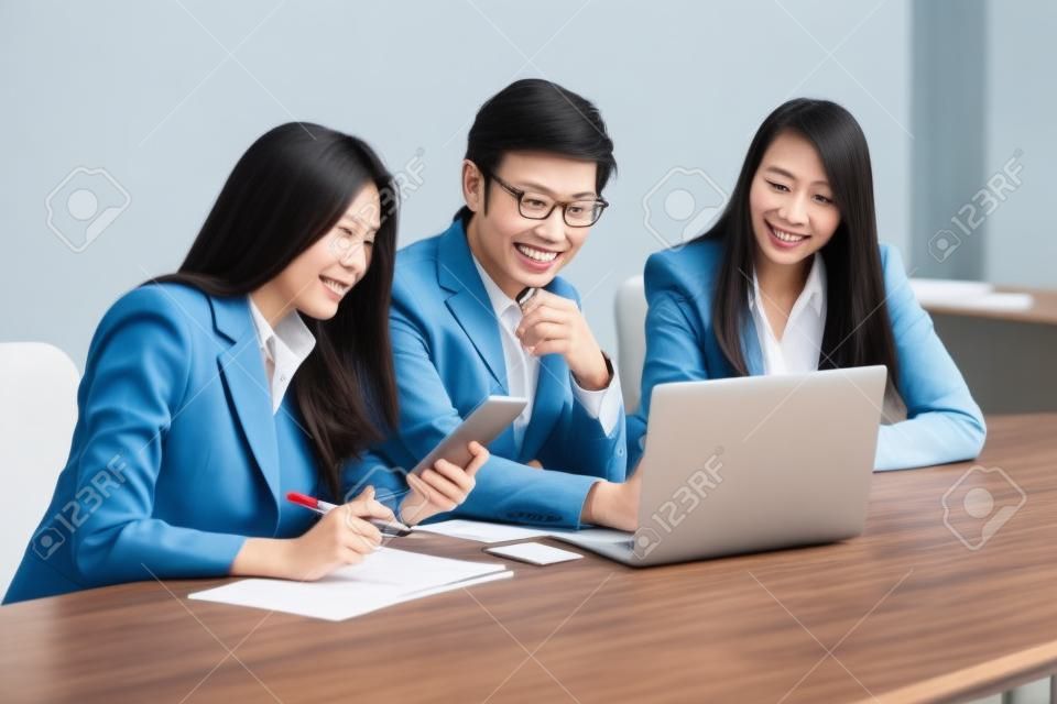 Pessoas de negócios asiáticos fazem uma discussão em grupo na sala de reunião com documento e computador colocando na mesa de madeira