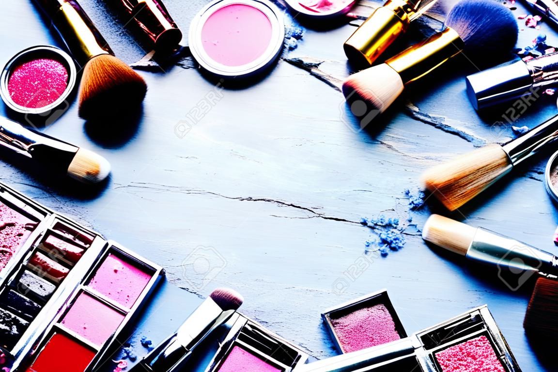 Bunte Rahmen mit verschiedenen Make-up Produkte auf dunklem Hintergrund