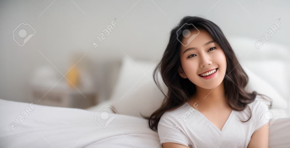 Il ritratto di giovane bella donna asiatica si rilassa nella sua camera da letto. Sorriso felice adolescente asiatico isolato su sfondo bianco banner.