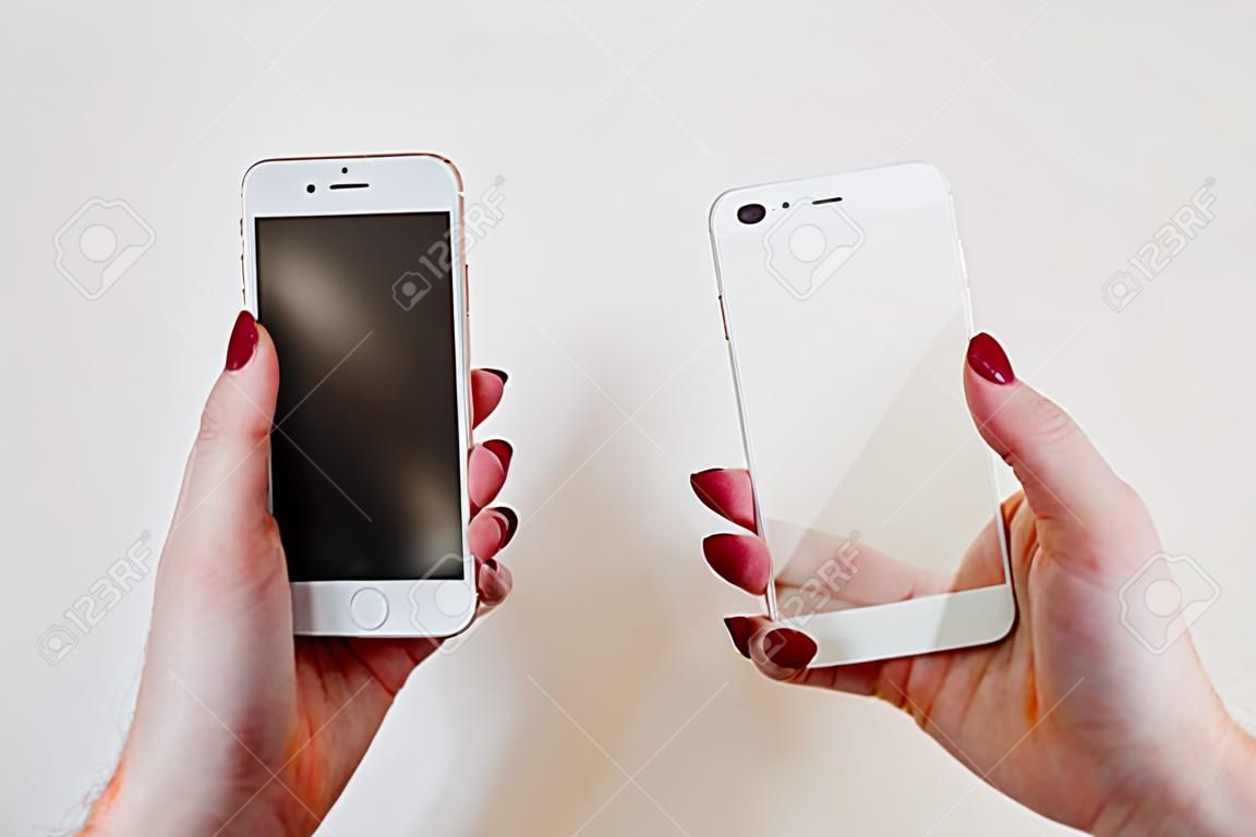 Smartphone with screen protect glass cover in hands. White background.