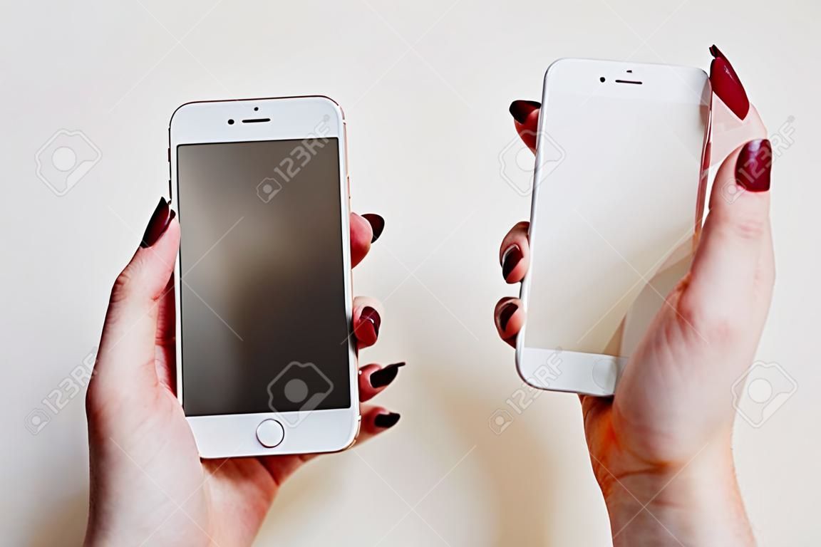 Smartphone with screen protect glass cover in hands. White background.