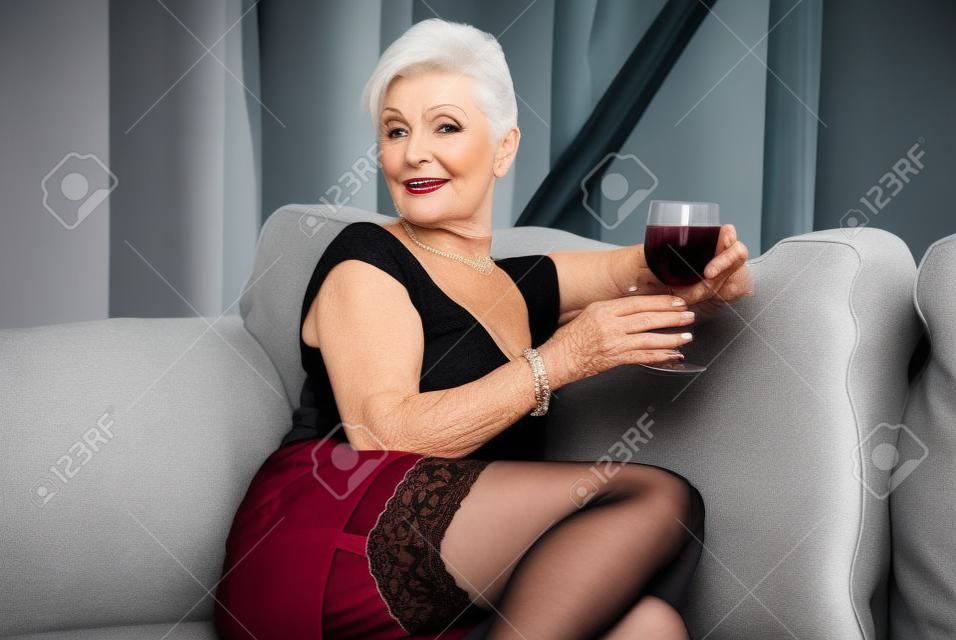 Mujer mayor en medias con vino