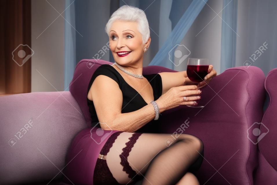 Mujer mayor en medias con vino