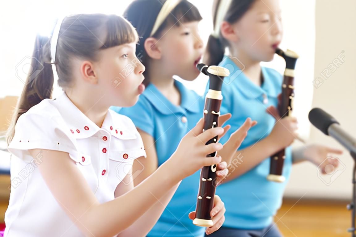Elementary school girls blow the recorder