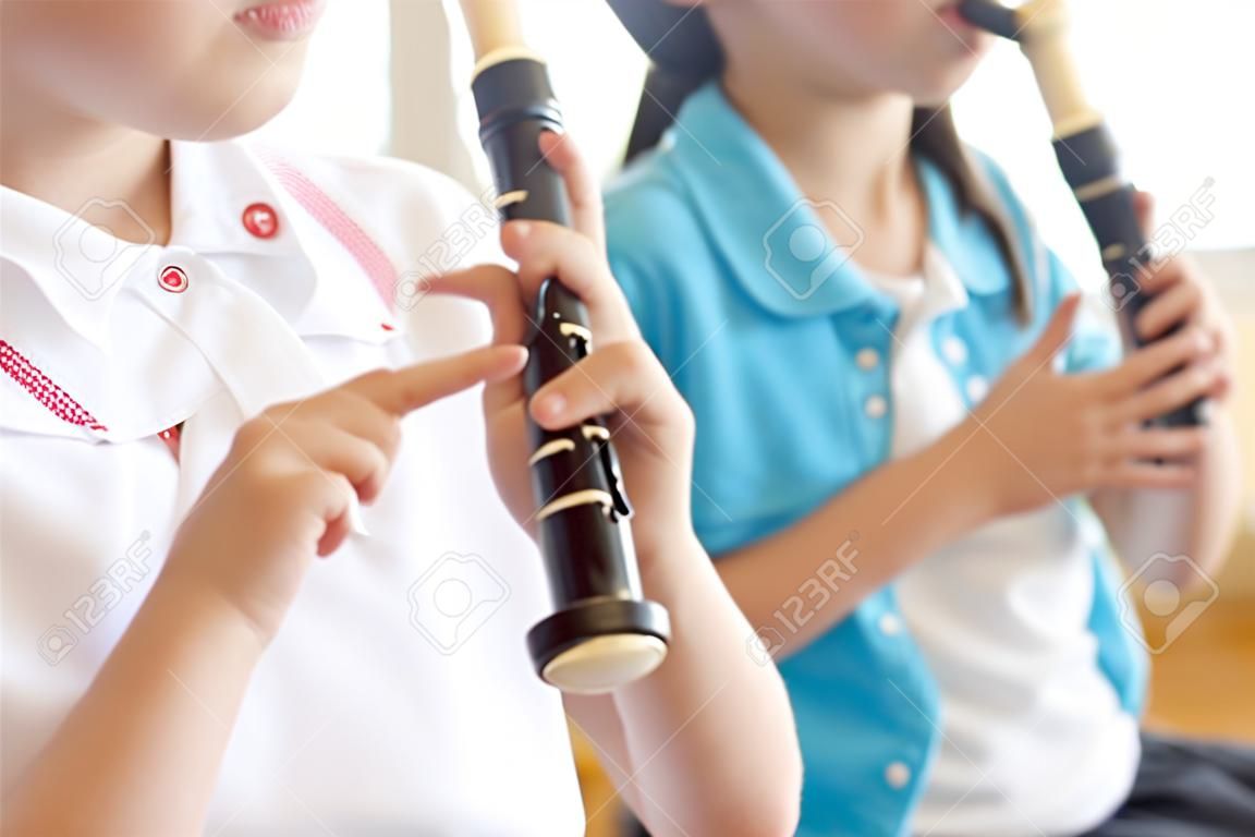 Elementary school girls blow the recorder