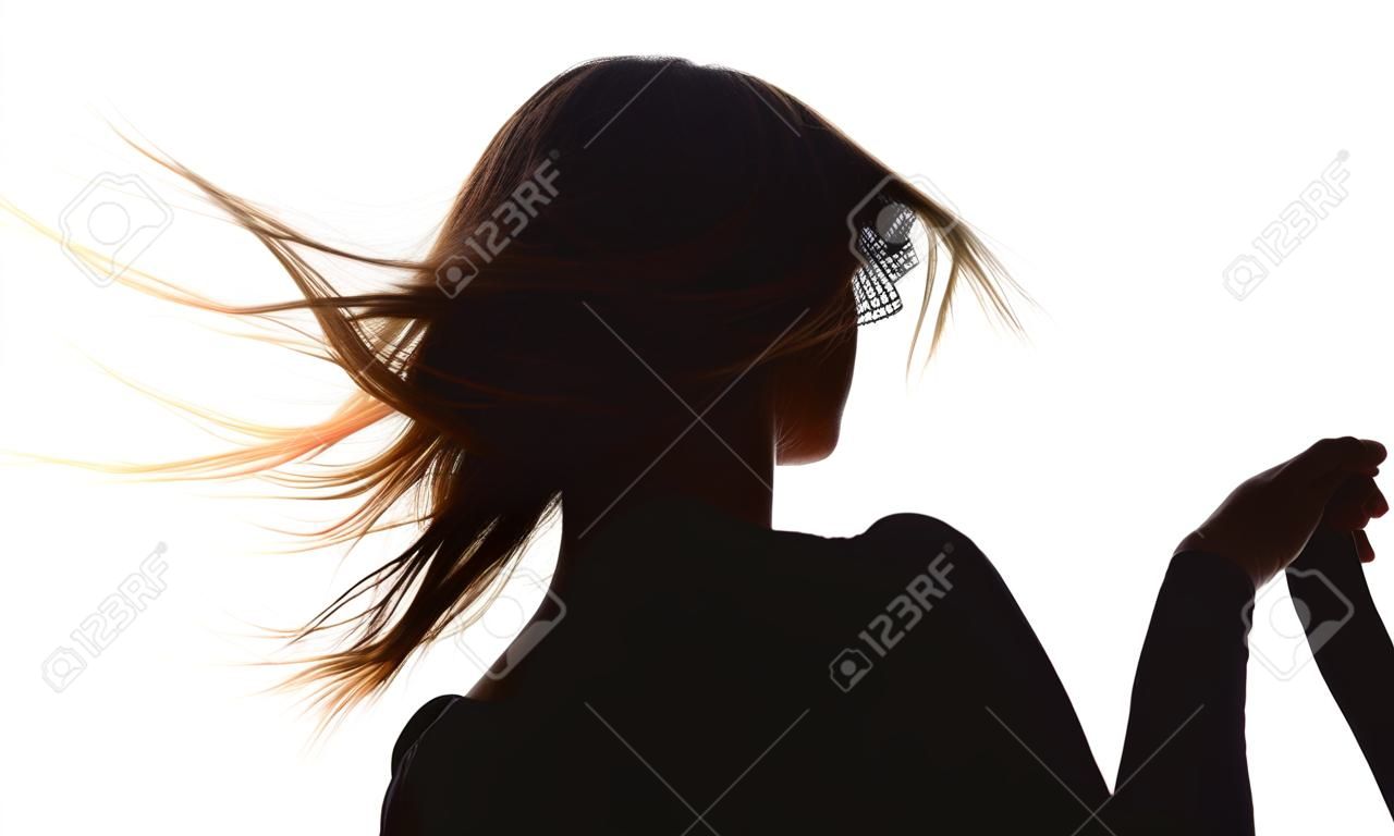 Silhouettieren Sie den Rücken einer Frau mit dem Wind, der vom Wind im Hintergrund des weißen Himmels fließt