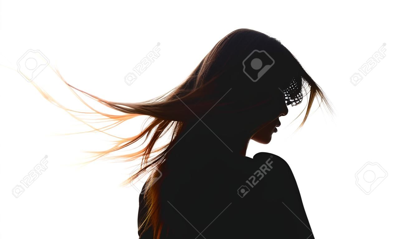 Silhouettieren Sie den Rücken einer Frau mit dem Wind, der vom Wind im Hintergrund des weißen Himmels fließt