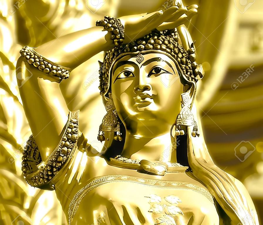 Earth goddess bronze statue  closeup on face in Thai style temple same concept as mother earth named Gaia in Greek mythology golden vintage tone