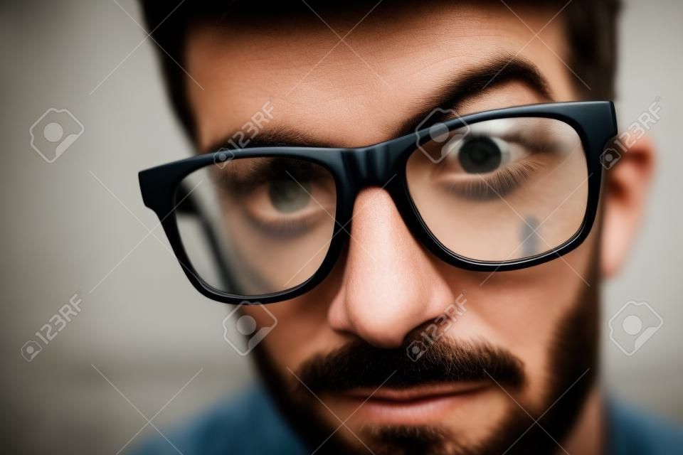 Looking into the eyes of a Hipster. Portrait close up of a man with hipster glasses on.