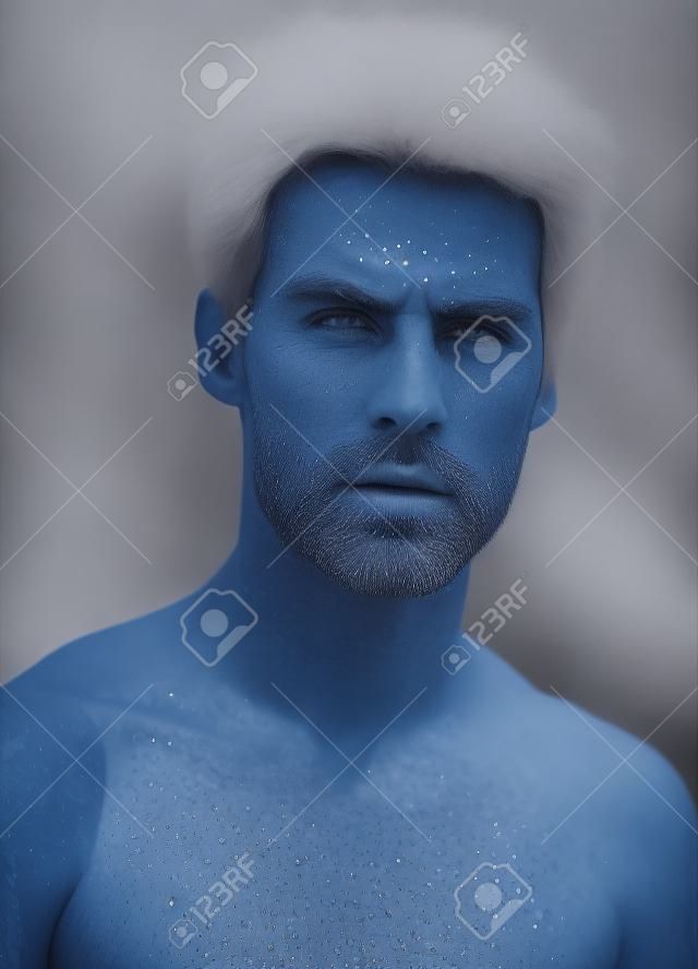 반짝이는 파란 눈으로 당신을 똑바로 바라보고 있습니다. 잘 생긴 남자의 초상화입니다.