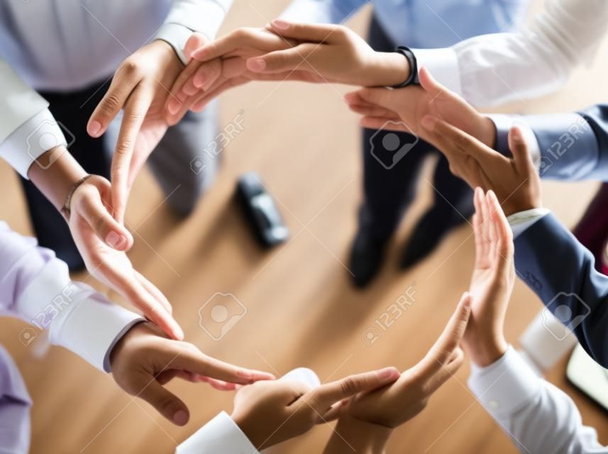 Our strength is connected and forms a circle. Closeup of a group of unrecognizable businesspeople holding hands in a certain way to form a circle inside of the office.