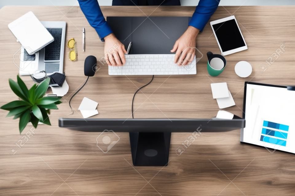 A estação de trabalho onde tudo acontece. Tiro de ângulo alto de um homem de negócios usando um computador em sua mesa em um escritório moderno.
