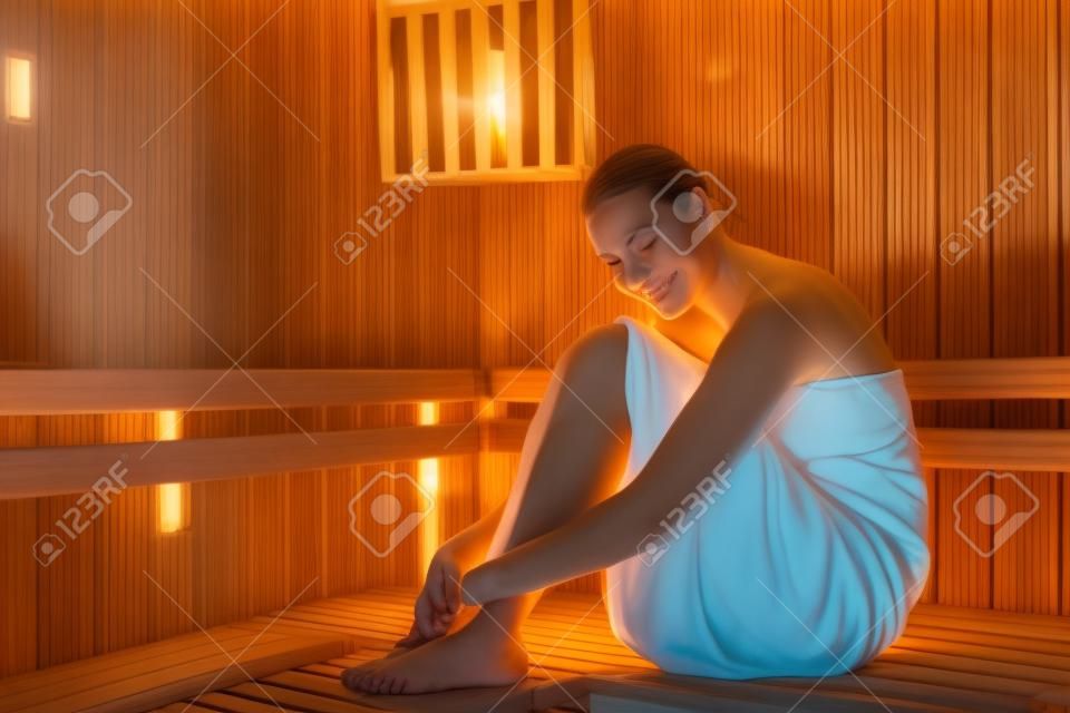 Poddanie się spokojowi. pełny portret młodej kobiety relaksującej się w saunie w spa.