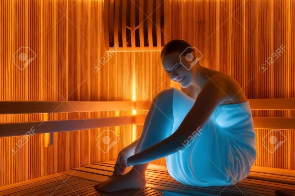 Sich der Gelassenheit hingeben. Ganzkörperporträt einer jungen Frau, die sich in der Sauna in einem Spa entspannt.