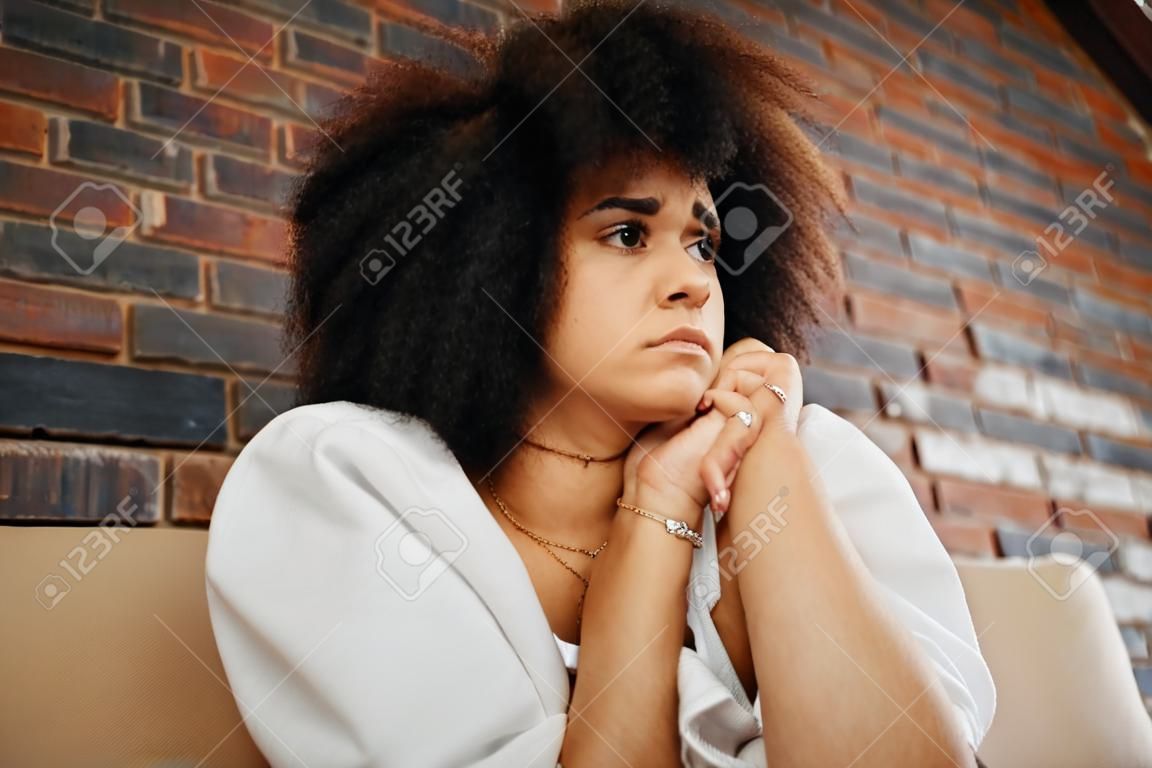 Femme fatiguée, déprimée et triste pensant au divorce, à la dépression et au stress anxieux avec un problème de santé mentale sur le canapé à la maison. fille africaine souffrant d'épuisement professionnel, traumatisée par la maltraitance et frustrée par une erreur