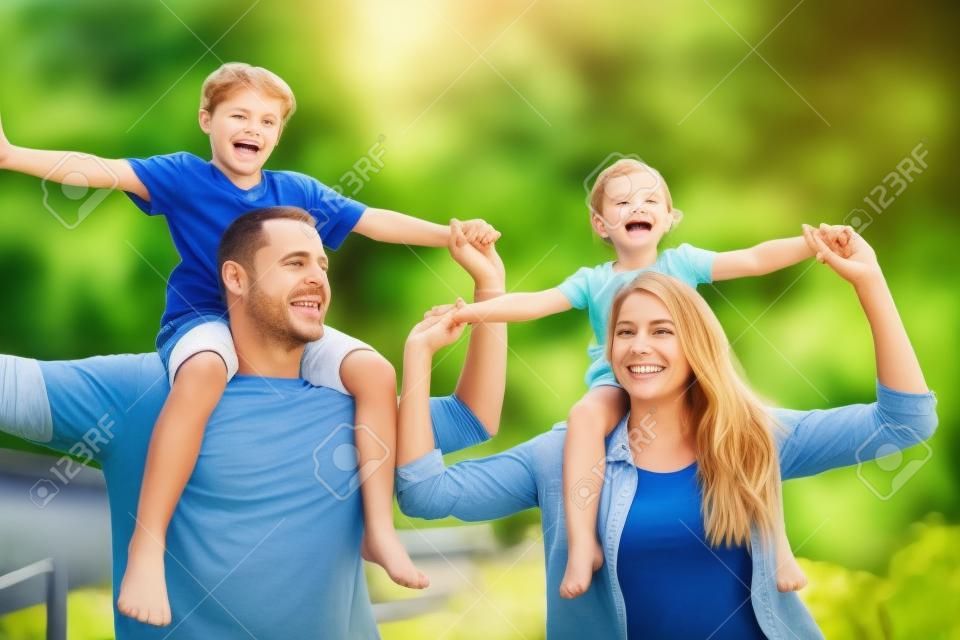 Schenken Sie ihnen die bestmögliche Kindheit. eine glückliche Familie, die sich im Freien zusammenschließt.