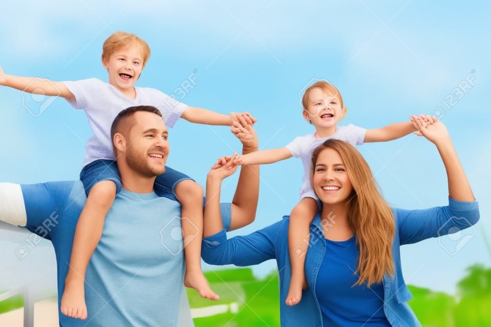 Schenken Sie ihnen die bestmögliche Kindheit. eine glückliche Familie, die sich im Freien zusammenschließt.