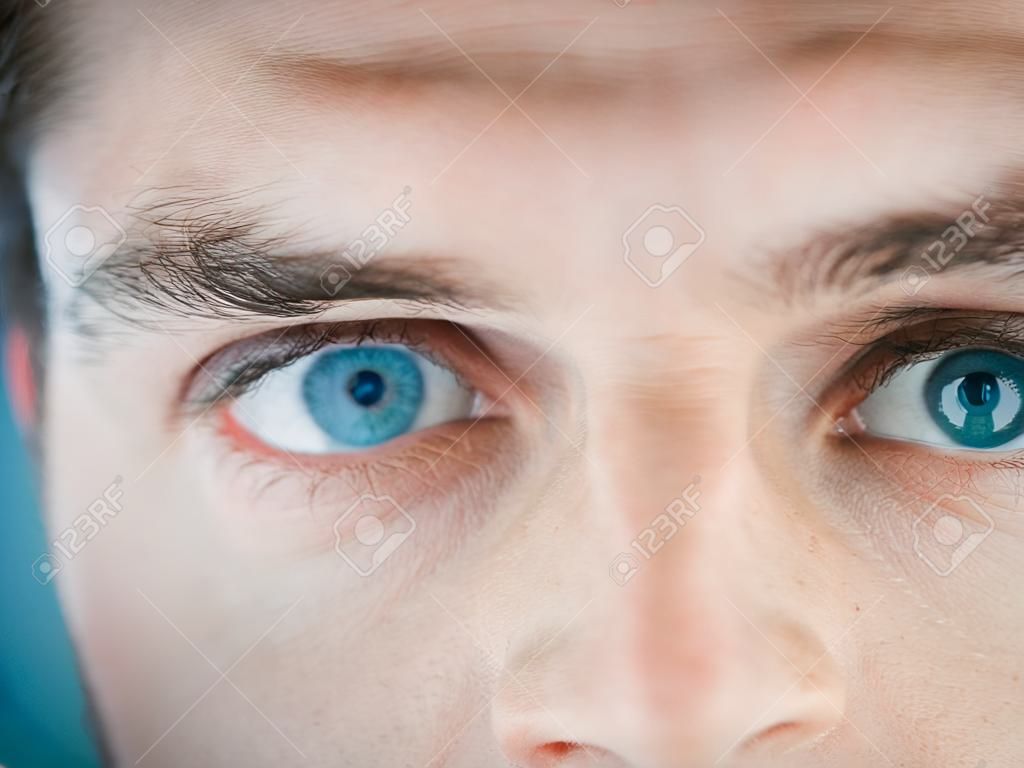 Half face, eye and man with free space for advertising and marketing eye care, contact lenses and vision for bright future. Macro of blue eyes male for security, biometrics and identity recognition