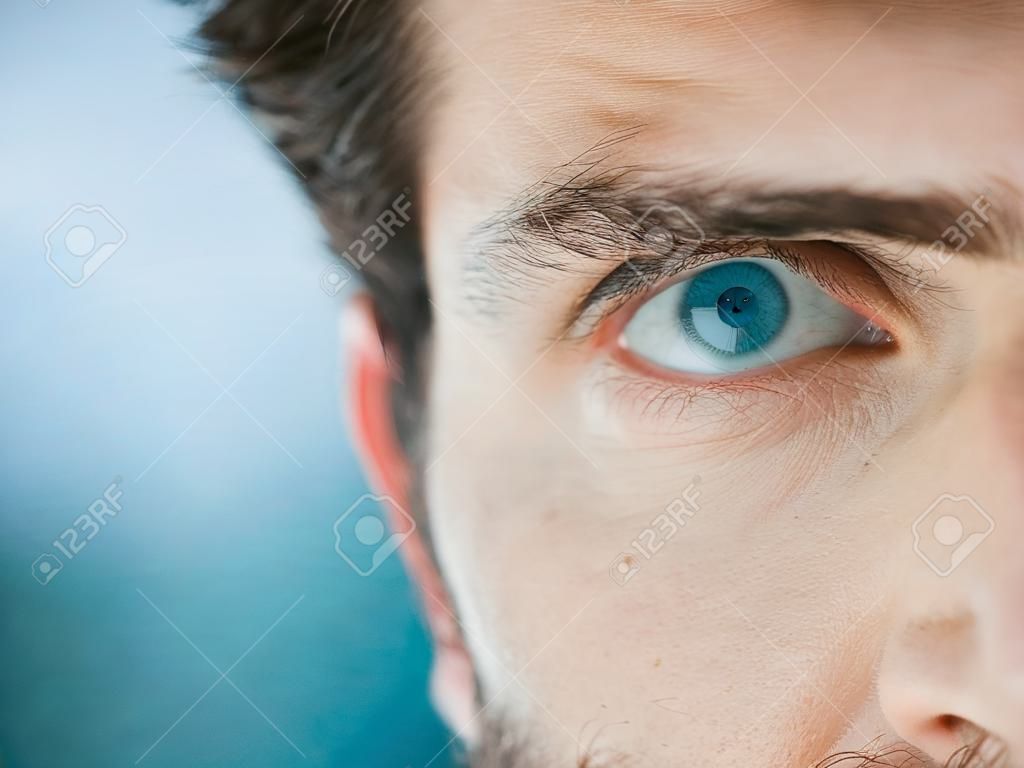 Mezza faccia, occhio e uomo con spazio libero per pubblicità e marketing cura degli occhi, lenti a contatto e visione per un futuro luminoso. macro di occhi azzurri maschio per sicurezza, biometria e riconoscimento dell'identità