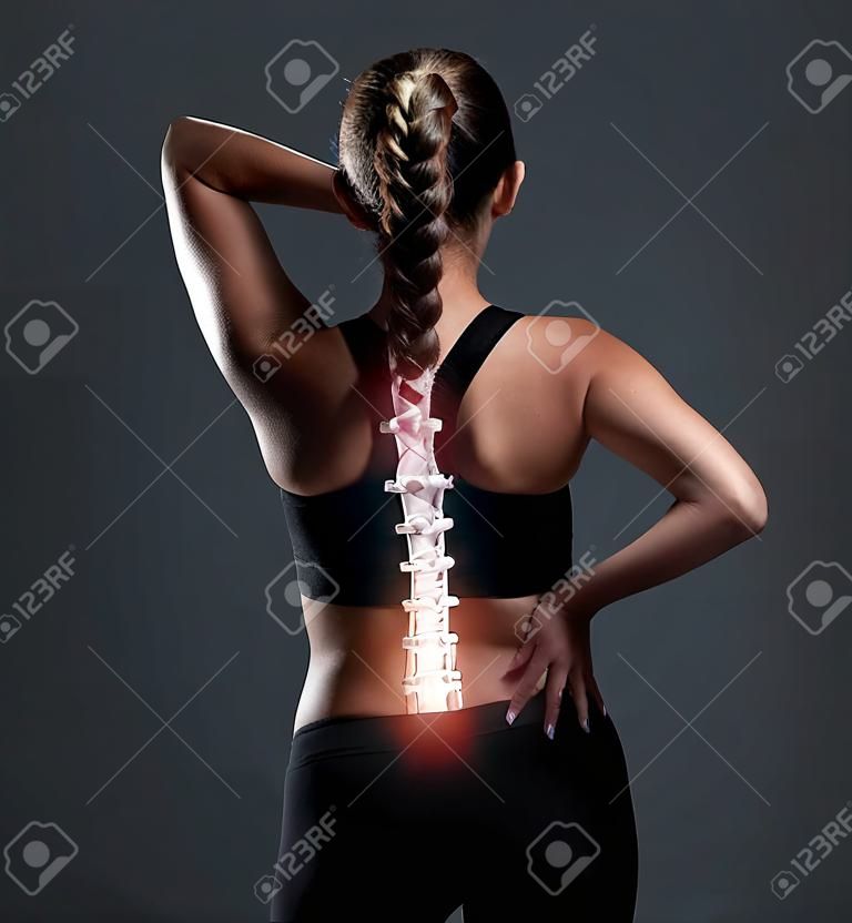 Ich könnte jetzt einen Wundertäter gebrauchen. Rückansicht einer sportlichen jungen Frau, die sich vor Schmerzen den Rücken hält.