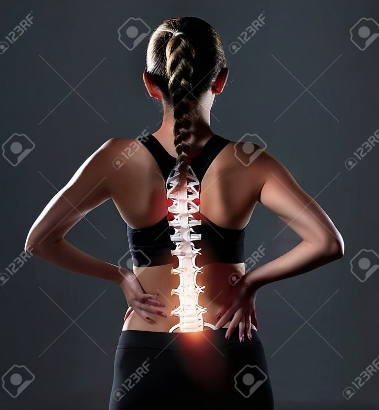 Ich könnte jetzt einen Wundertäter gebrauchen. Rückansicht einer sportlichen jungen Frau, die sich vor Schmerzen den Rücken hält.
