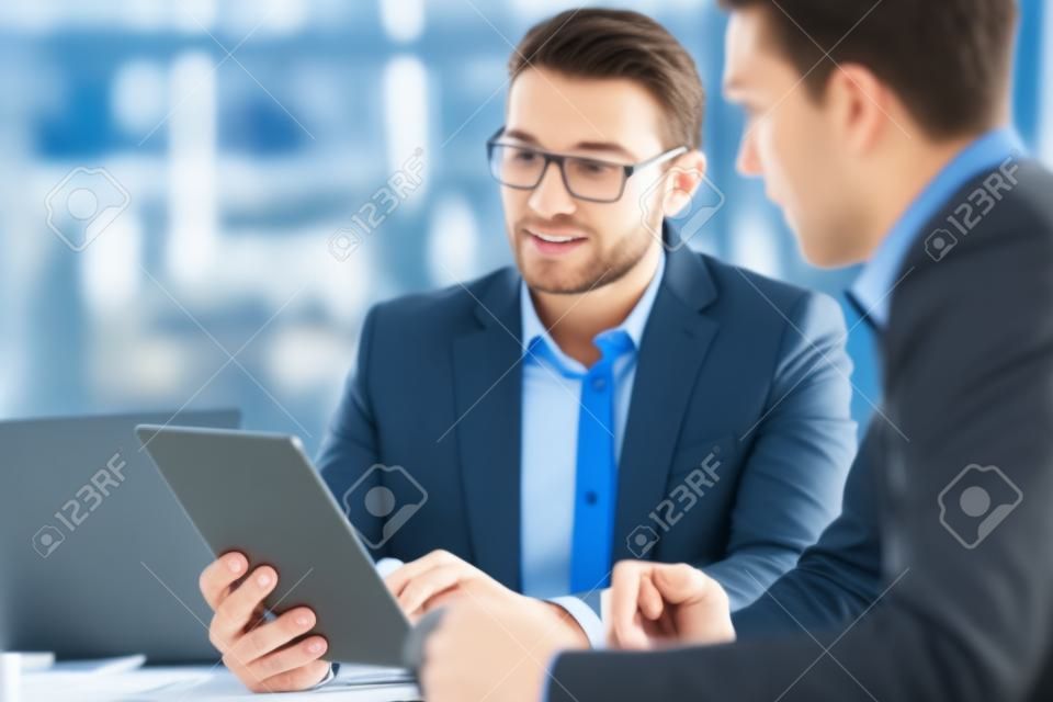 Tablet, meeting and teamwork of business people in office discussion. Collaboration, technology and men or employees with touchscreen planning sales, marketing or advertising strategy in company.
