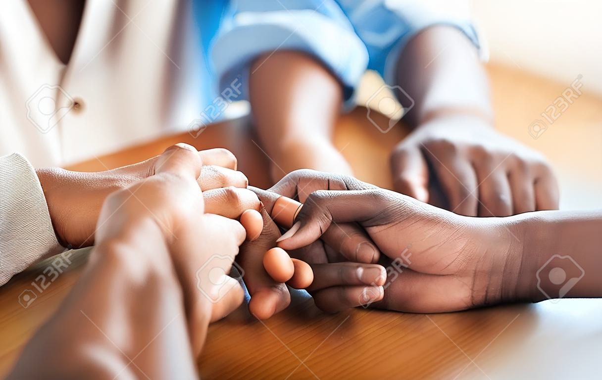 Together we can overcome anything thrown our way. Closeup shot of two unrecognizable people holding hands in comfort at home.