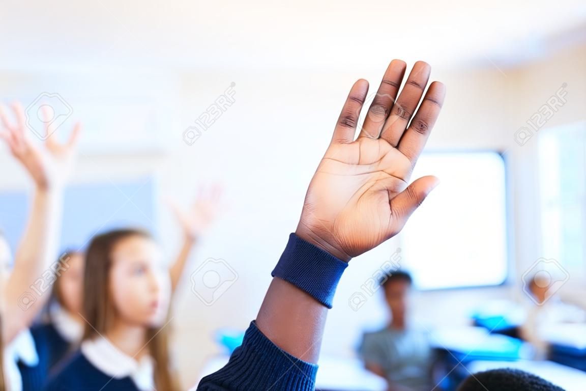 그는 수업 시간에 손을 들고 있는 알아볼 수 없는 대표팀 학생의 모든 답을 알고 있습니다.