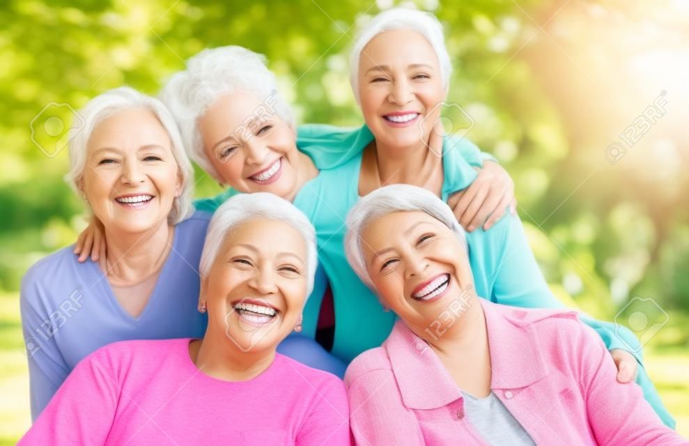 Sonrisa, parque y retrato de un grupo de mujeres que disfrutan juntas del vínculo, del tiempo de calidad y del relax en la naturaleza. diversidad, amistad y rostros de mujeres mayores felices con calma, bienestar y paz al aire libre