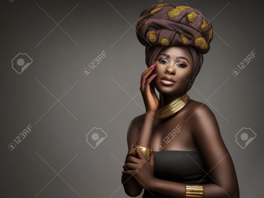 Vous n'êtes pas fait pour vous fondre dans l'arrière-plan, photo en studio d'une belle jeune femme portant un bandeau africain traditionnel sur un fond gris.