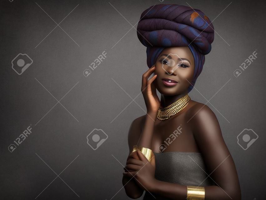 You werent made to blend into the background. Studio shot of a beautiful young woman wearing a traditional African head wrap against a grey background.