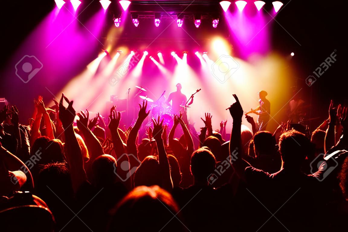 Festival, music and concert with energy of crowd cheering for live rock band on stage. Event, fans and happy people cheer for energetic performance at music festival in Los Angeles, USA.