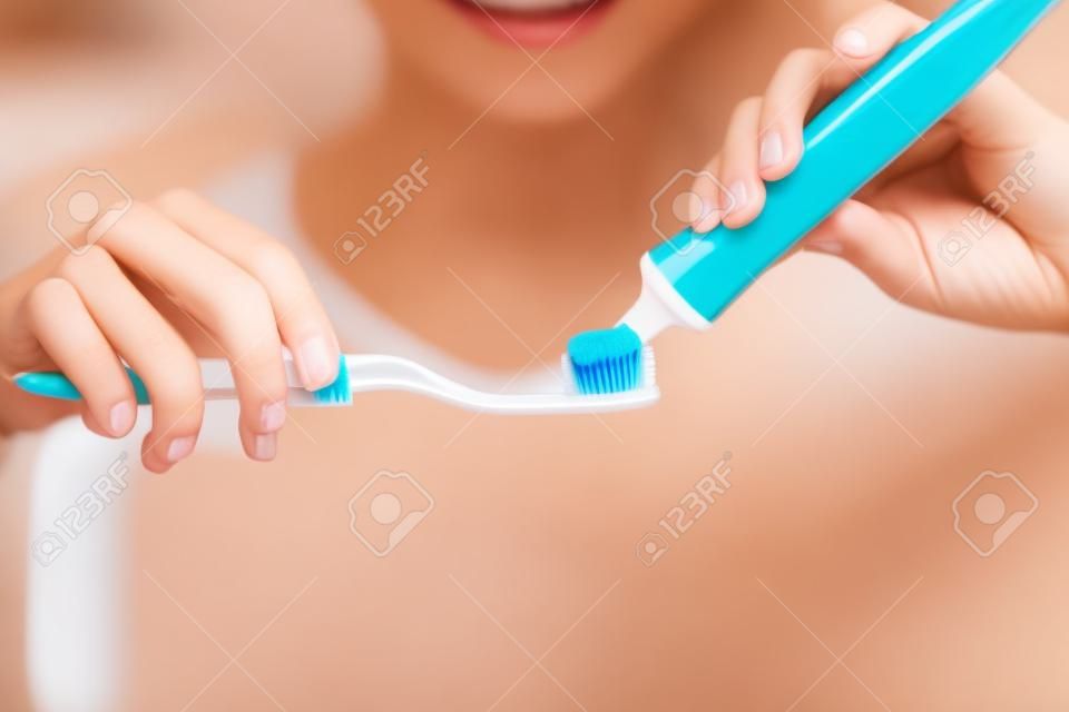 Just a little goes a long way. Closeup shot of a young woman squeezing toothpaste onto her toothbrush in the bathroom at home.