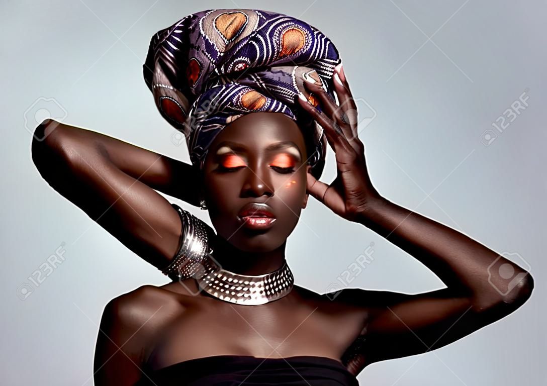 Maquillage de mode africaine et femme noire en studio sur fond blanc avec des cosmétiques de luxe et du luxe glamour de beauté et le visage d'une personne féminine brille dans un style traditionnel de bijoux exotiques et une écharpe